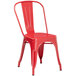 A red metal Lancaster Table & Seating outdoor table with chairs.