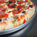 An American Metalcraft deep dish pizza pan with a pizza topped with pepperoni and olives.