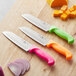 A group of Choice Santoku knives with colorful handles.