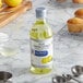 A bottle of McCormick Culinary Pure Lemon Extract on a counter next to muffins.