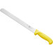 A white bread knife with a yellow handle.