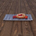 A blue textured Elite Global Solutions melamine platter with a pastry and strawberries.