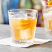 A Pasabahce Casablanca old fashioned glass with a drink, ice, and orange slices.