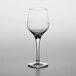 A clear Nude wine glass on a white surface.