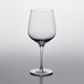 A clear Nude Refine wine glass on a white surface.