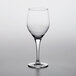 A close-up of an empty Nude Primeur wine goblet on a white background.