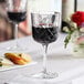 A Pasabahce Timeless Vintage wine glass filled with red wine on a table.