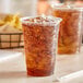 A pair of EcoChoice PLA compostable plastic cups filled with ice tea with straws.