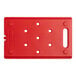 A red plastic board with holes for food pans.