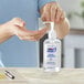 A person using a pump of Purell hand sanitizer.