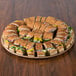 A Solut Kraft corrugated catering tray with sandwiches on a table.