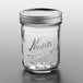 A Kerr clear glass canning jar with a silver metal lid.