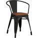A Lancaster Table & Seating black metal chair with a walnut wood seat.