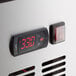 A digital thermostat with red numbers on a Cooking Performance Group countertop griddle.
