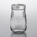 A Ball clear glass flute canning jar with silver metal lid.