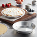 A Baker's Mark deep dish pie in a silver pan with whipped cream and berries.