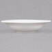 A close up of a CAC white porcelain fruit dish with a rim.