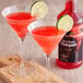Two glasses of red Regal Strawberry Daiquiri Mix with lime slices on the rim.