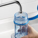 A person using a blue Vigor Polar Paddle to fill a water bottle.