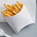 A white paper tray of French fries.