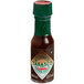 A close up of a TABASCO Chipotle hot sauce mini bottle.