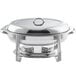 A stainless steel Choice Deluxe oval chafer with chrome accents and two lids on a table outdoors.