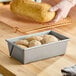 A rectangular glazed aluminized steel bread loaf pan filled with dough, measuring 8 1/2 inches by 4 1/2 inches by 2 3/4 inches.