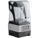 A Vitamix blending station with a clear Tritan container and a glass cover.