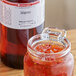 A bottle of LorAnn Oils All-Natural Jalapeno Super Strength Flavor next to a jar of red sauce.