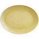 A close-up of a beige oval porcelain platter with a glossy finish.