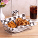 A chrome rectangular basket filled with fried food and a glass of soda.
