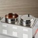 A stainless steel Choice steam table adapter plate with bowls of red sauce in it.