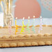 A cake with Creative Converting Curly Assorted Pastel Color Candles on top.
