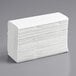 A large stack of white Lavex C-Fold paper towels.