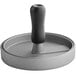 A black and white metal hamburger press with a wooden handle.