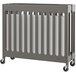 A Foundations Boutique Dapper Gray wood crib with wheels.