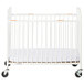 A white Foundations StowAway EasyRoll compact crib with wheels.
