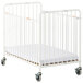 A white Foundations StowAway EasyRoll folding crib with wheels.