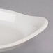 A Hall China ivory oval rarebit dish on a gray surface.