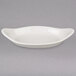 A white oval dish with a curved edge on a gray surface.