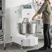 A large commercial spiral dough mixer with a stainless steel bowl and control panel, designed for heavy-duty mixing in a professional kitchen.