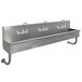An Advance Tabco stainless steel multi-station hand sink with 3 faucets.