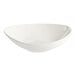 A close up of an Acopa Nova cream white stoneware bowl with an asymmetrical rim.