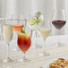 A group of Acopa Elevation flute glasses filled with white and red wine on a table.