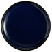 An Acopa Keystone Azora Blue stoneware coupe plate with a black rim and white spots on a dark blue background.