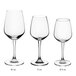 A row of three Acopa Radiance wine glasses with measurements on them.