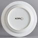 An Acopa Capri stoneware plate in coconut white with a white rim and black text that says Acopa.