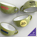 A set of moss green matte stoneware cups, each with a different custom logo or design on the side.