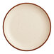 A round porcelain coupe plate with a vanilla bean color and a brown rim.