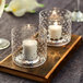 Two Acopa hobnail glass bowls on a wood tray with a pair of candles.
